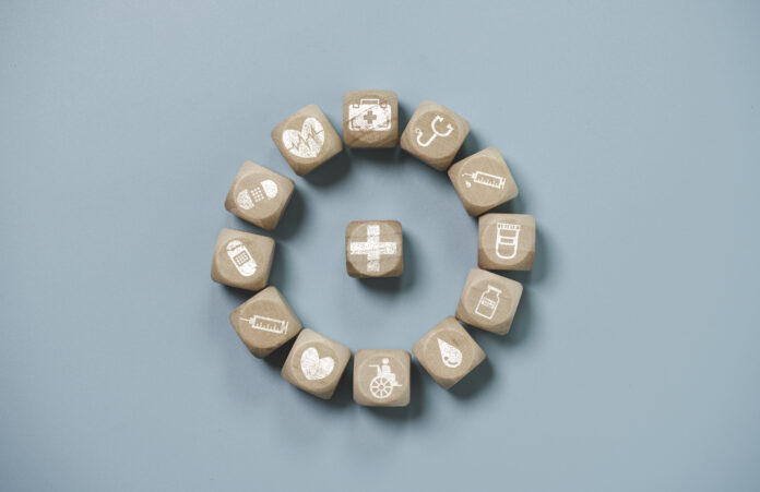 Wooden block cube which print screen health care and medical icons for healthy and wellness concept.